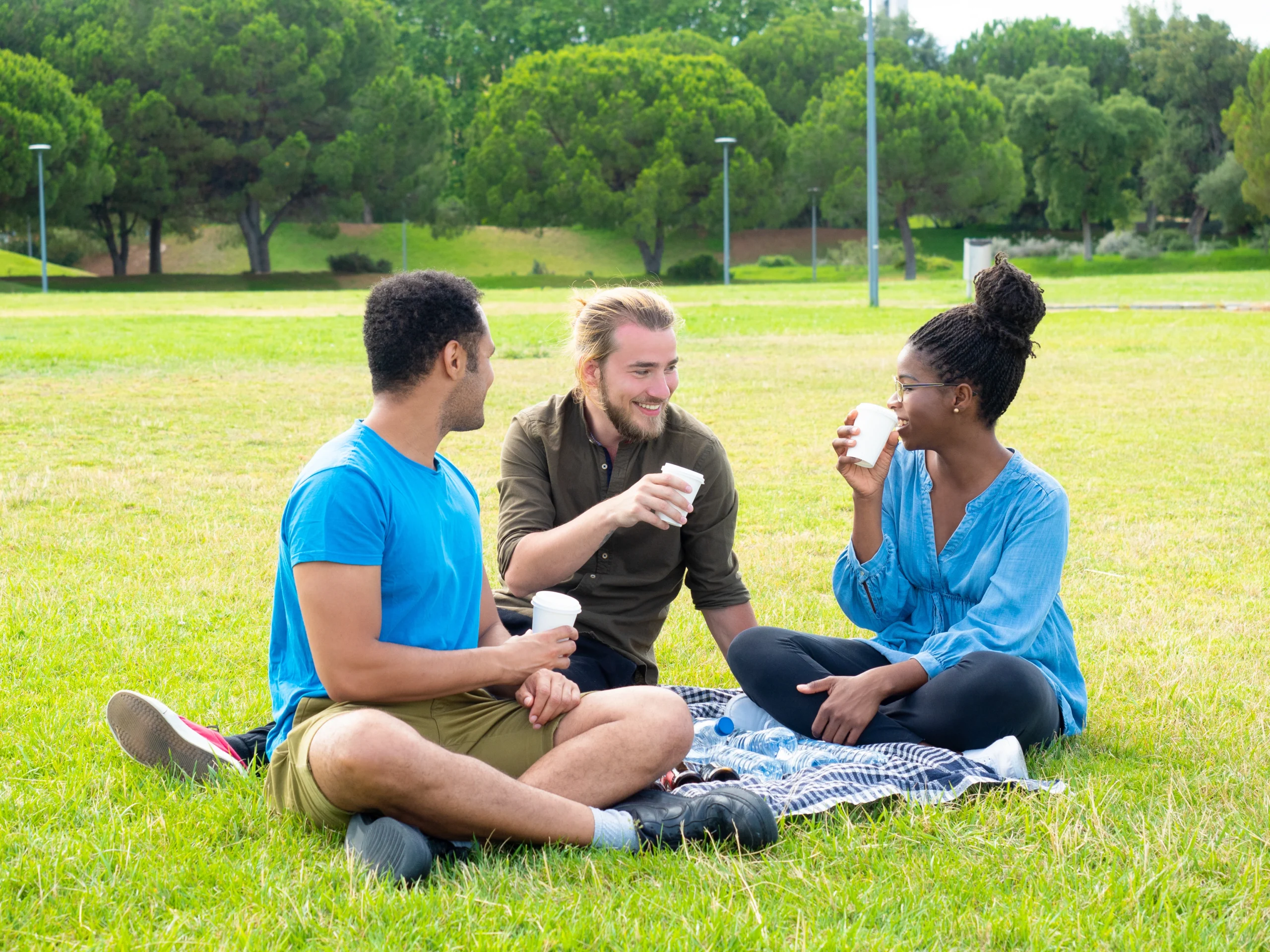 3People having fun in a park and drinking water.